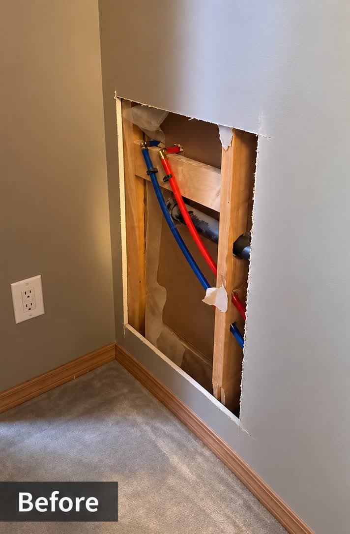 Drywall wall opening exposing Poly-B/PEX pipes before repair — Calgary