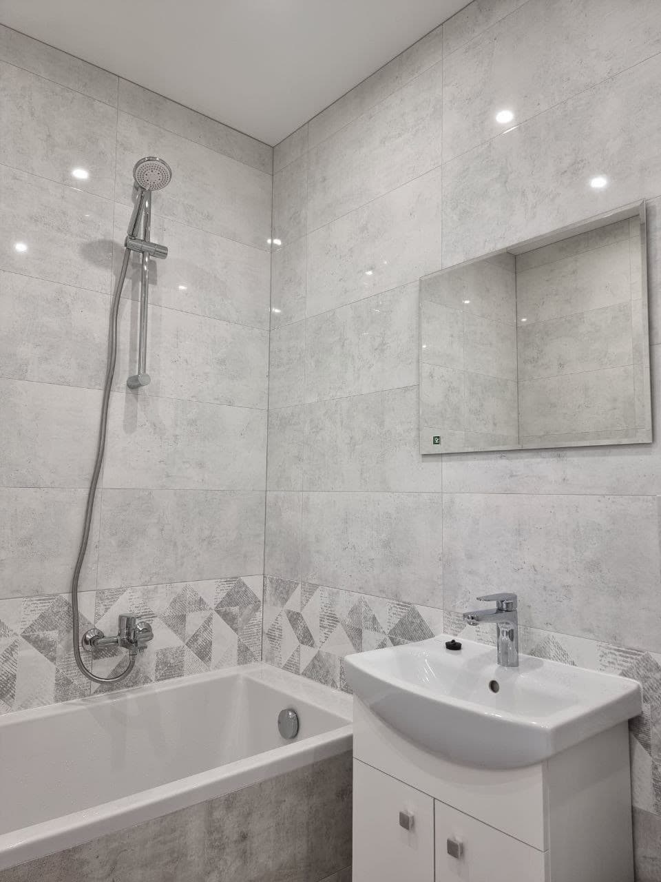 Renovated bathroom with a tiled shower, bathtub and floating vanity