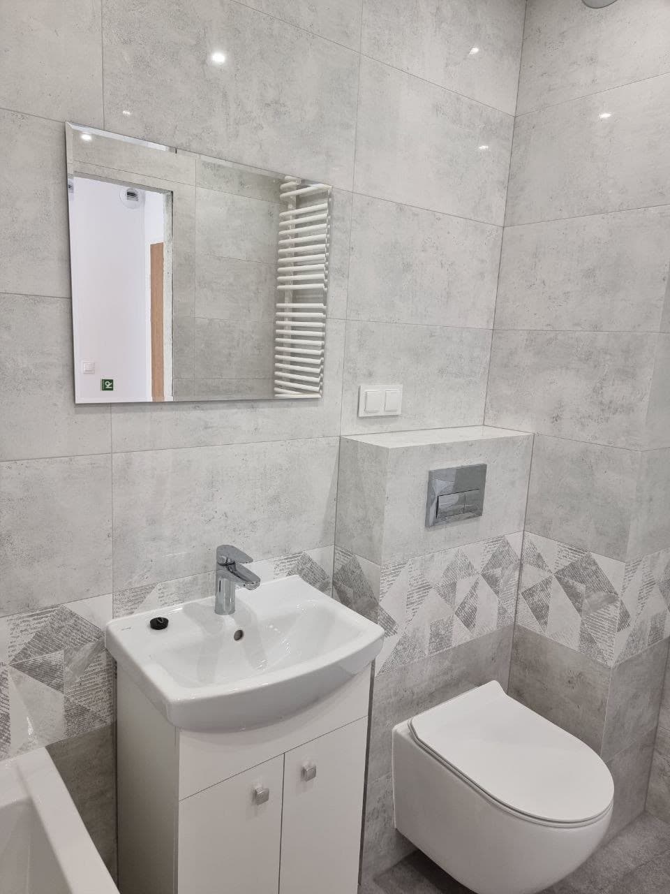 Bathroom vanity and mirror with a patterned feature-tile accent wall