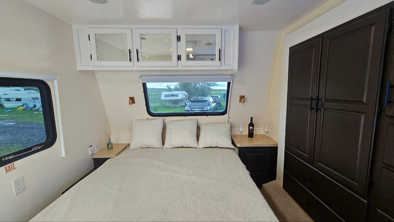 Renovated travel trailer bedroom with refinished cabinetry and fresh white walls