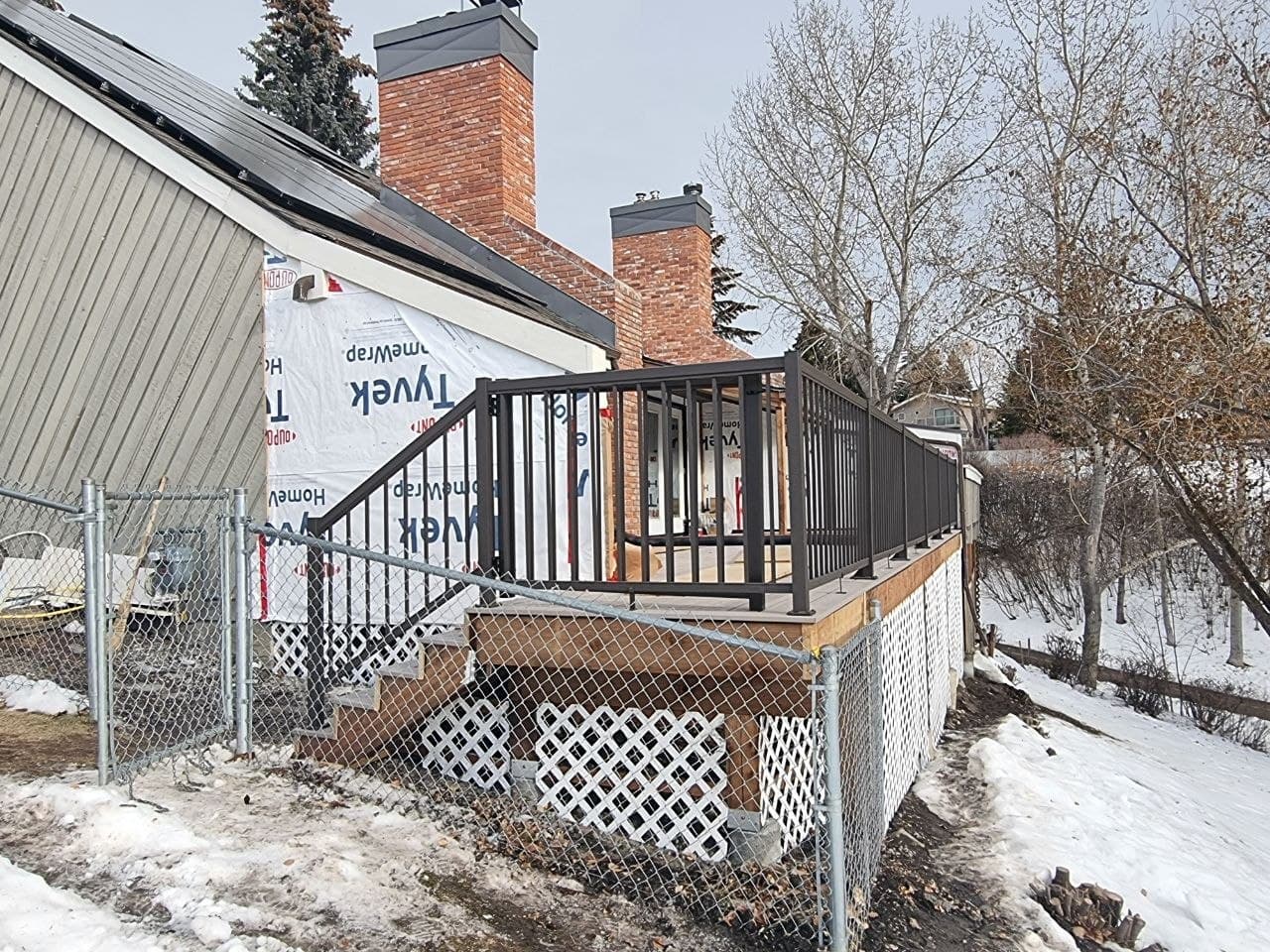 Finished composite deck with black aluminum railings on a Calgary home