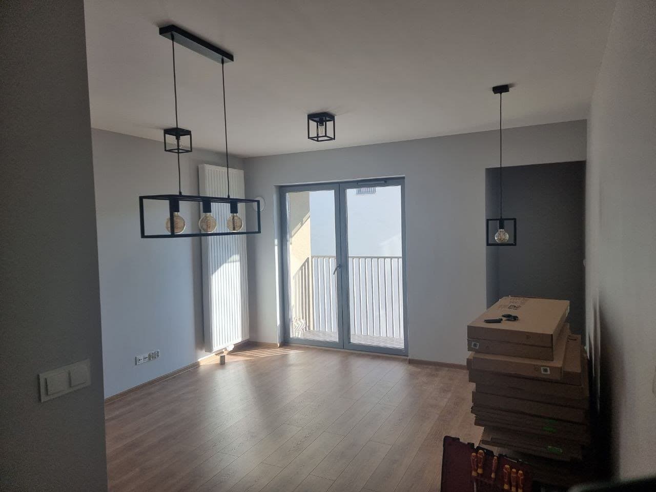 Freshly painted open-plan living space with pendant lighting