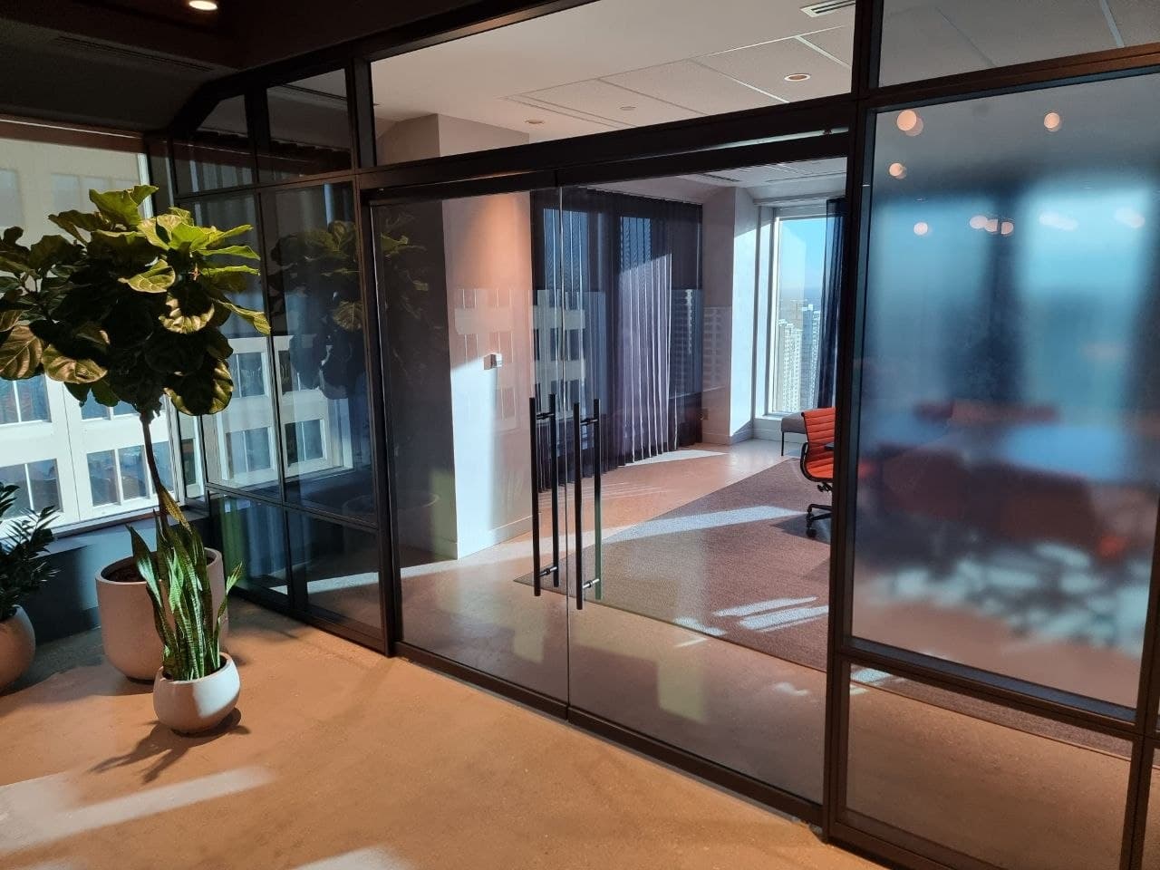 Finished black-framed glass office with a meeting room and downtown Calgary view