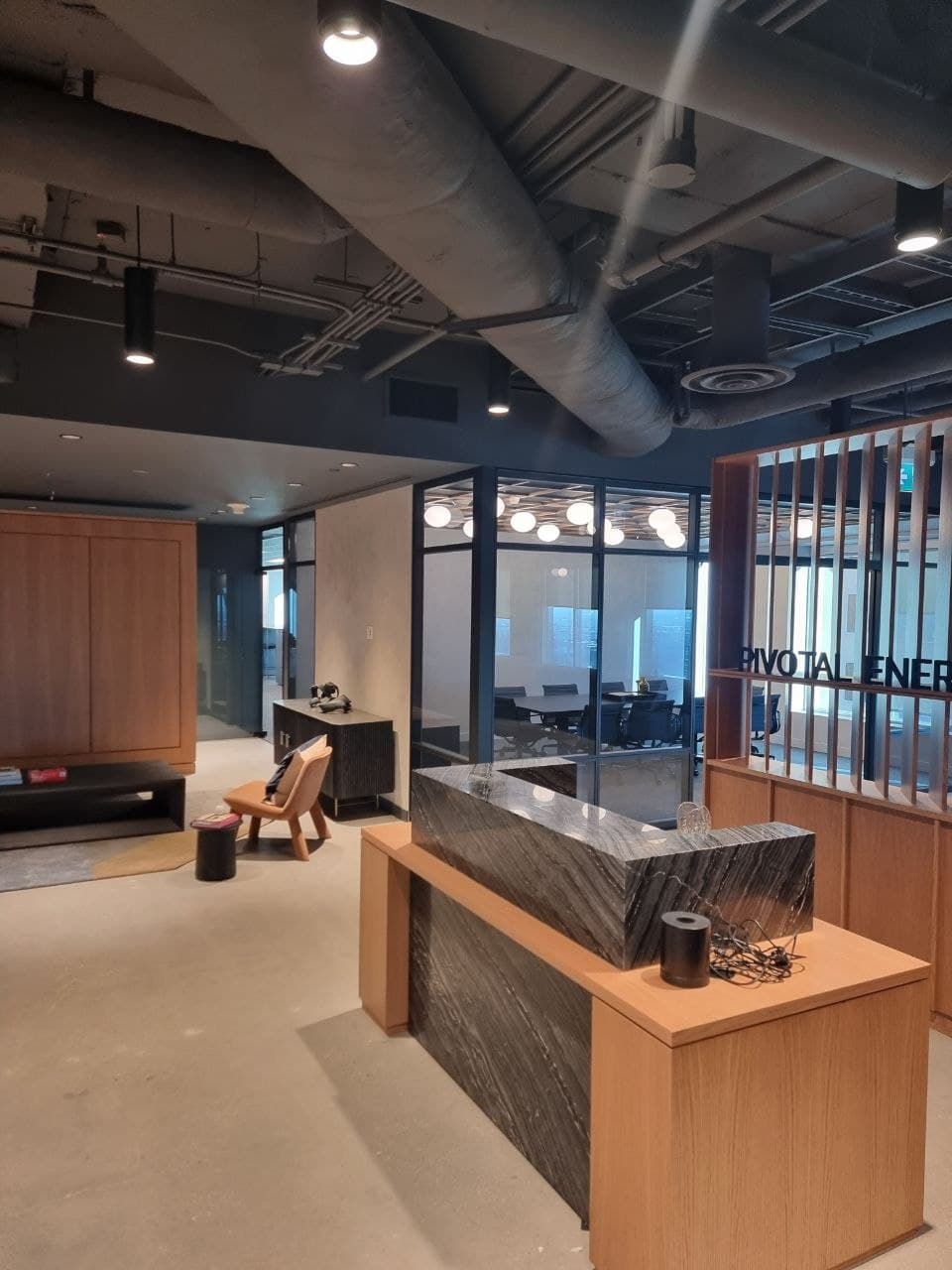 Corner glass-walled meeting room with globe lighting and downtown Calgary views