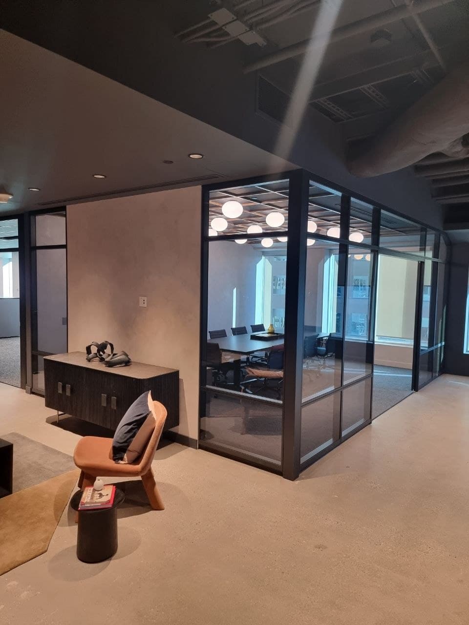 Glass-walled meeting room with globe lights and a downtown Calgary view